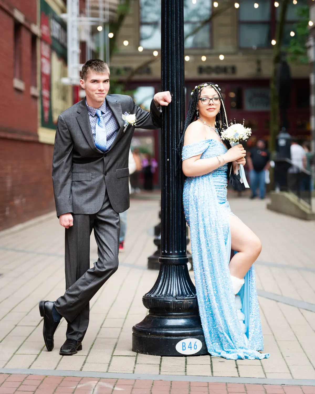 Couple in formal attire beside a streetlamp